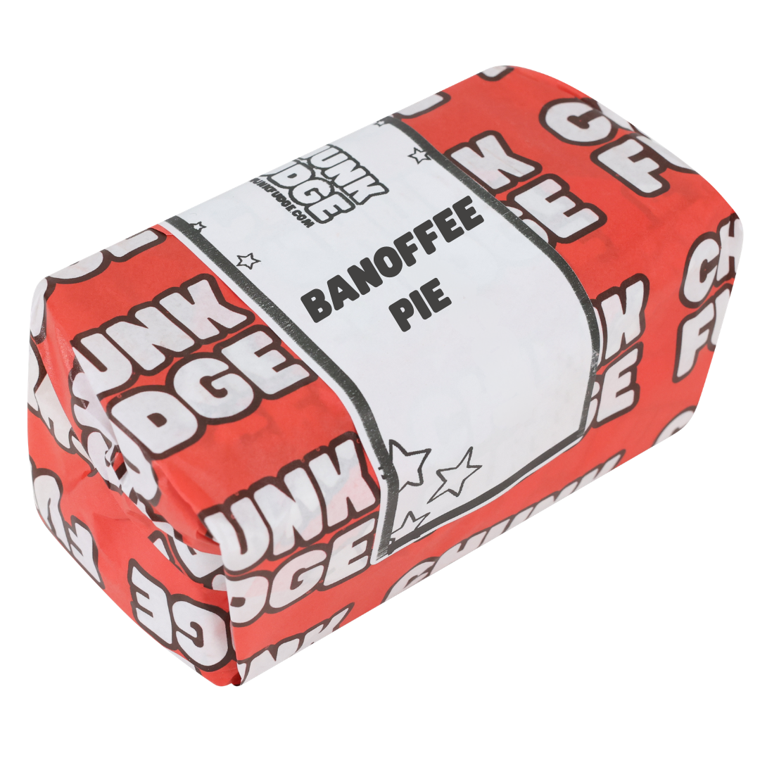 A rectangular package labeled Banoffee Pie Fudge, wrapped in red and white with a central white label, features luxury milk chocolate and rich banana fudge flavors.