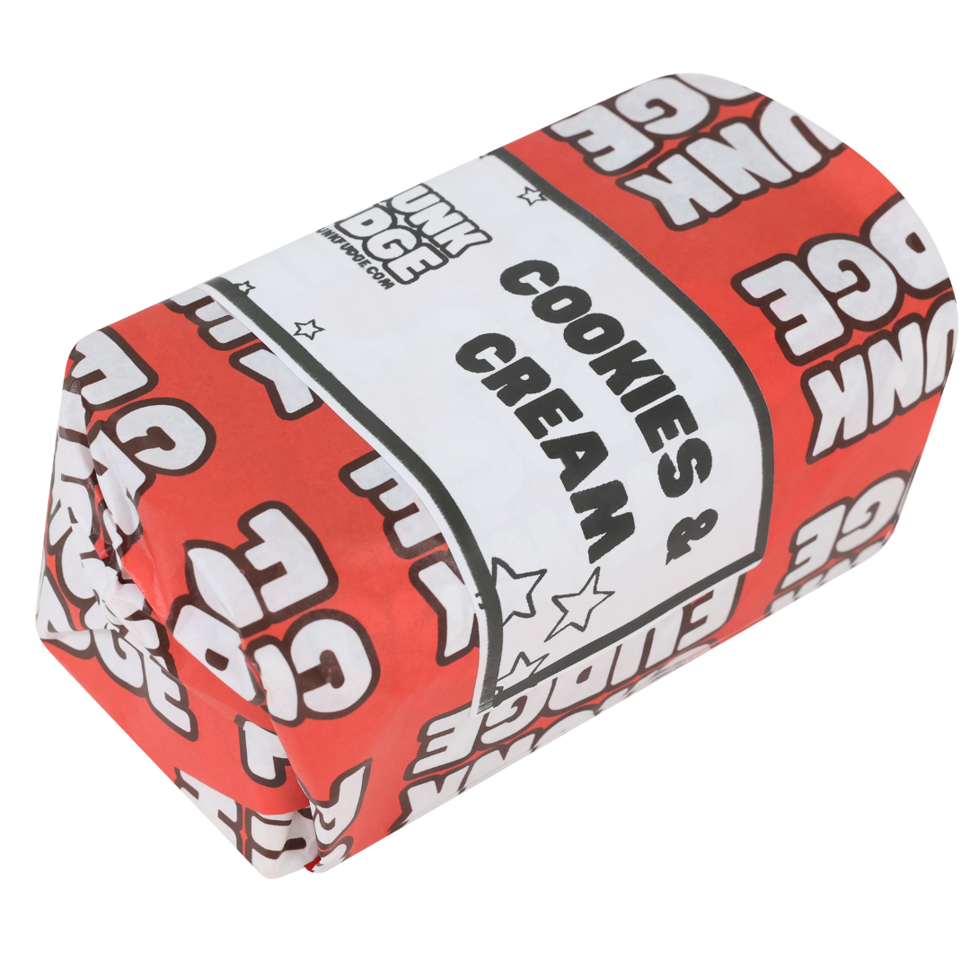 A wrapped food item in red and white paper labeled "Cookies And Cream Fudge," with repeating EDUNKI EDGE text and stars, hints at the rich, handmade flavor of Cookies And Cream Fudge inside.