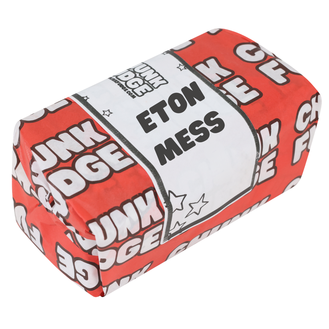 A rectangular block wrapped in red and white paper labeled "Eton Mess Fudge," decorated with stars, suggests a sweet treat combining creamy vanilla fudge and strawberry-flavoured chocolate.