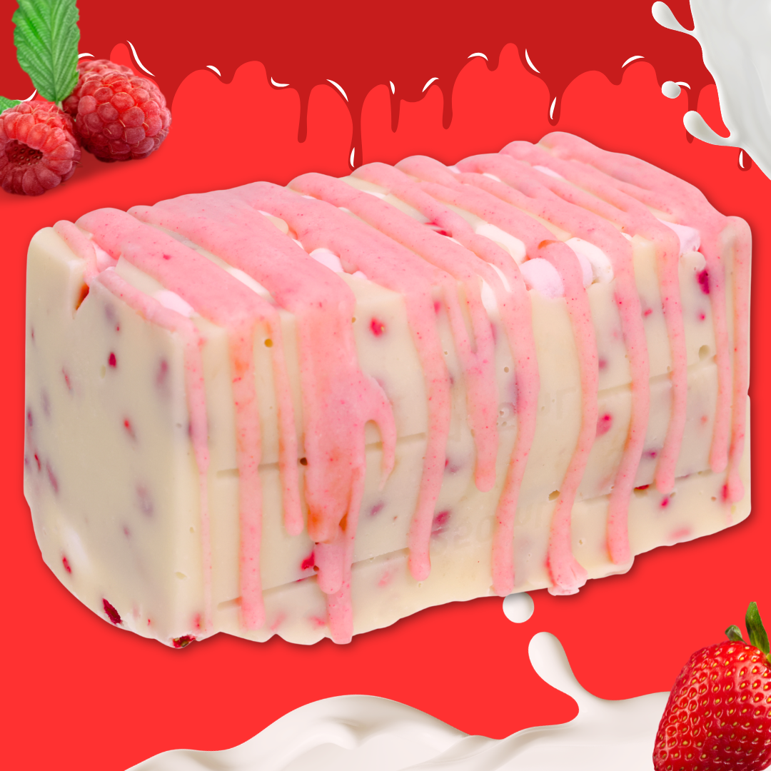 Eton Mess Fudge: a rectangular block of creamy vanilla fudge with swirls of white and pink ice cream, studded with strawberry and raspberry pieces, topped with pink sauce, set on a bright red background with milk splashes and whole berries.