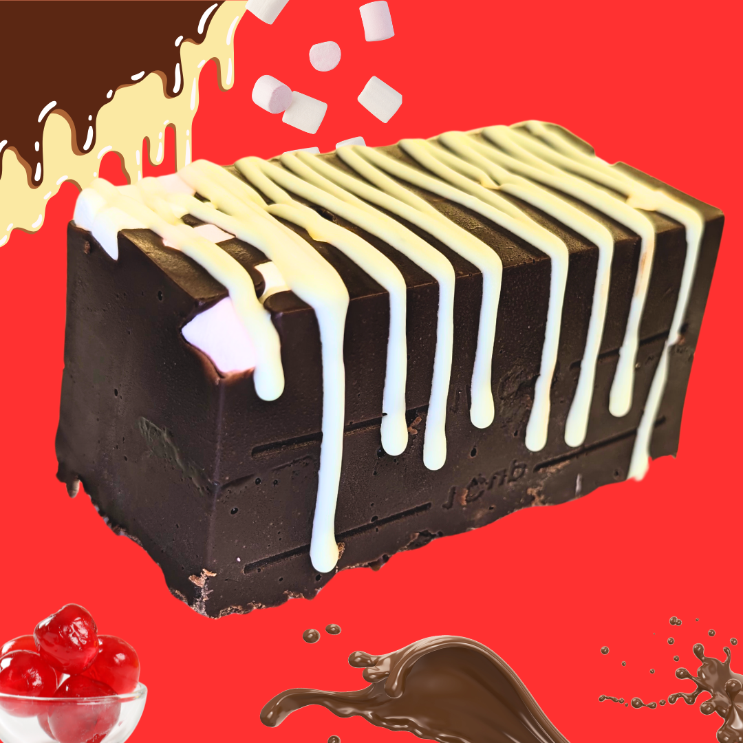 A slice of Rocky Road Fudge with white icing drizzle, marshmallow pieces, and a cherry garnish sits against a vibrant red background with chocolate and cream splashes.